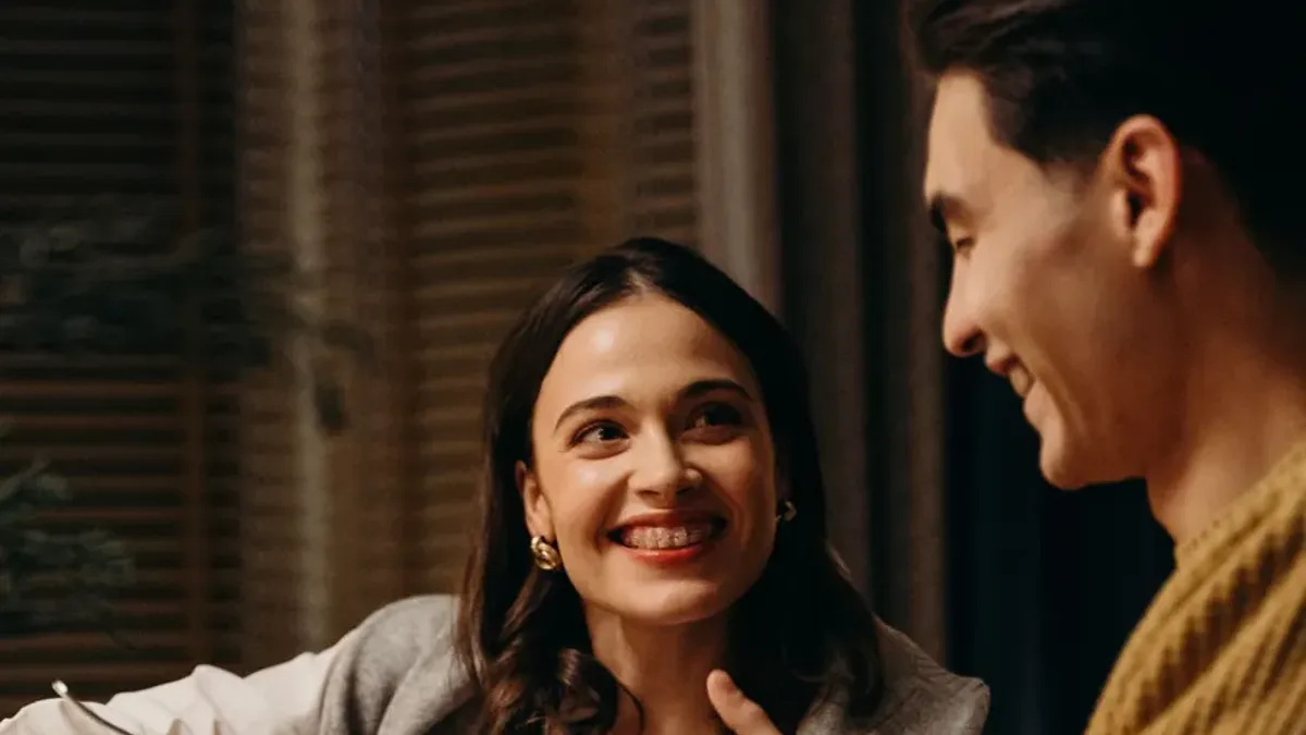 A couple smiling at each other at a dinner table