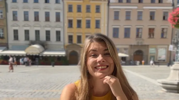 Weronika, a Polish teacher from Wrocław, smiling on the Market Square in Wrocław