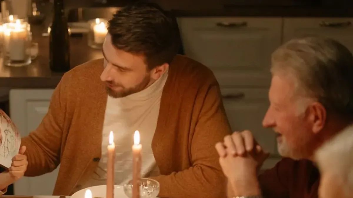 Family at a candle-lit Wigilia supper table on Polish Christmas Eve