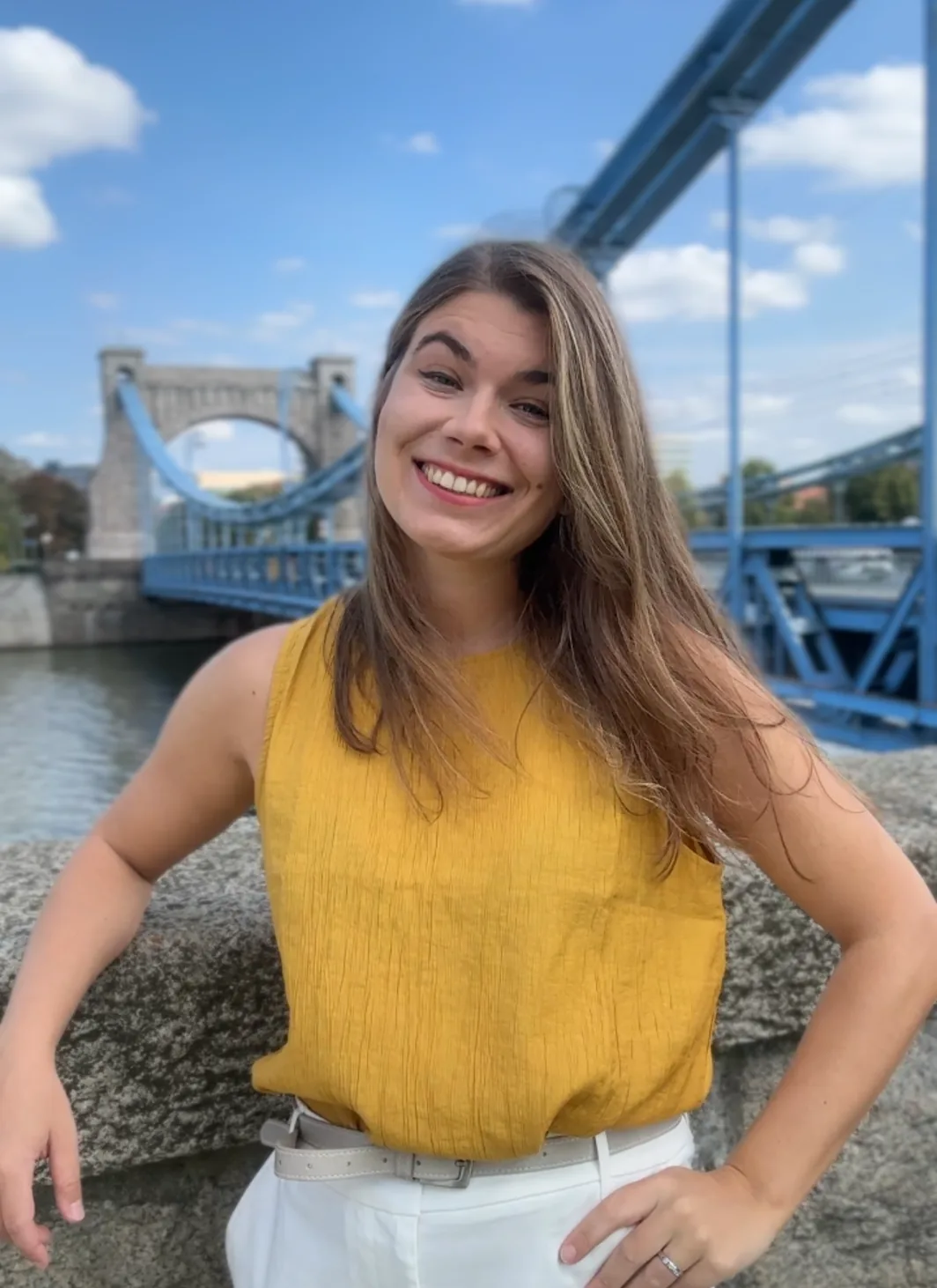 Weronika, certified Polish teacher, smiling by a river bridge