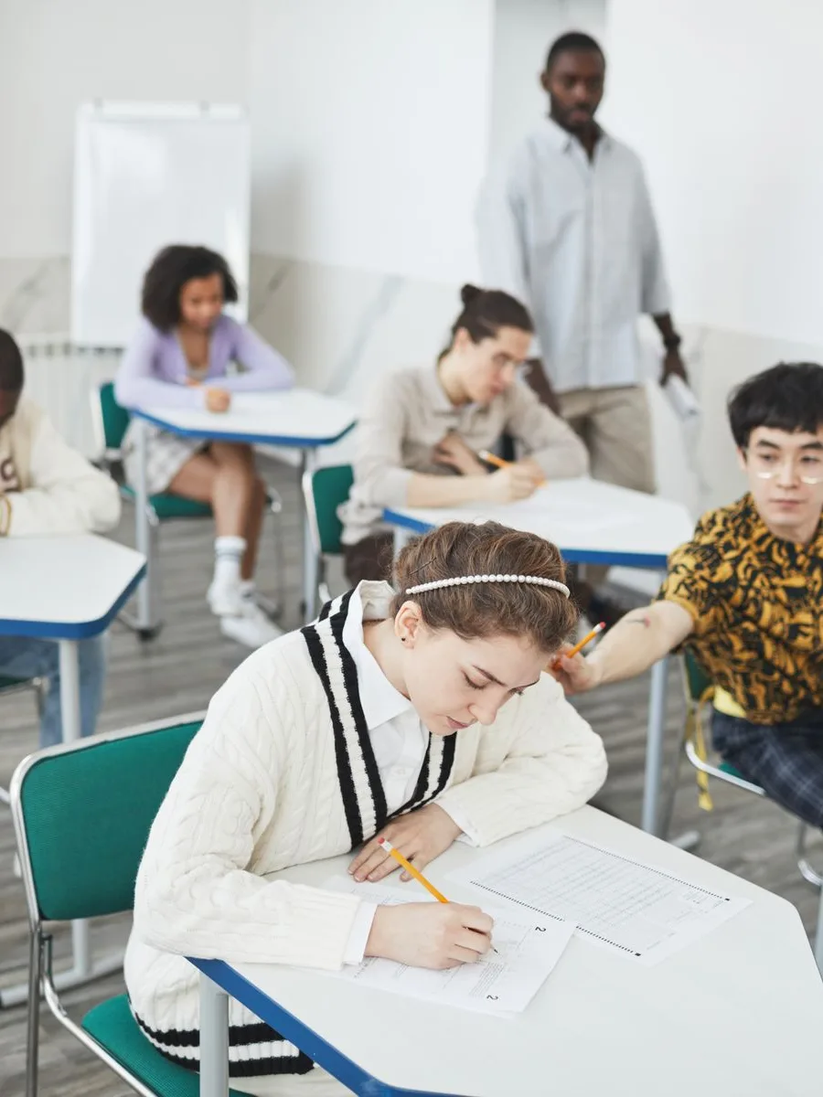 Adults sitting a written exam in a classroom