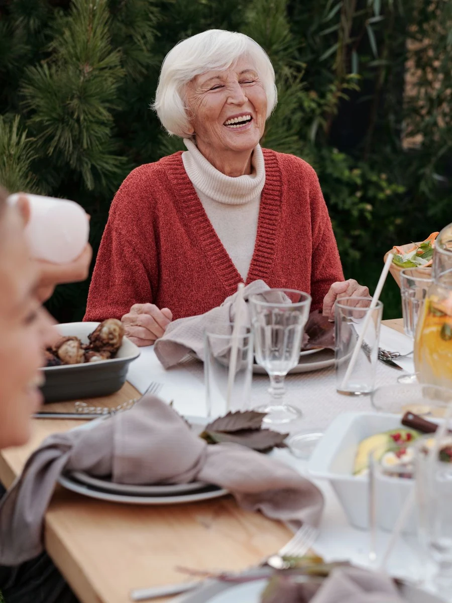 Grandmother laughing at the family table