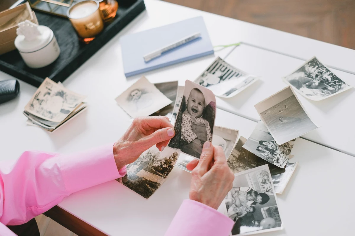 Hands holding old black-and-white family photographs