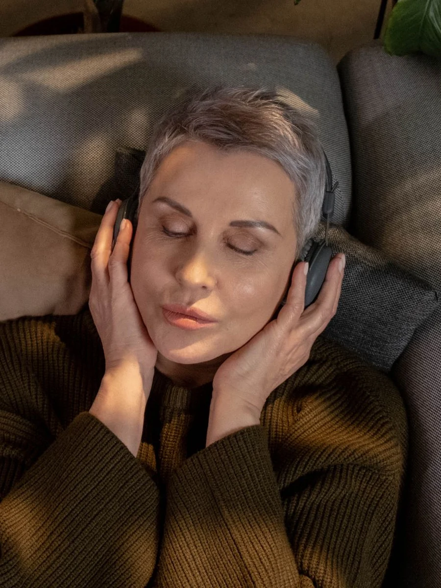 Woman with headphones and closed eyes, lost in a song