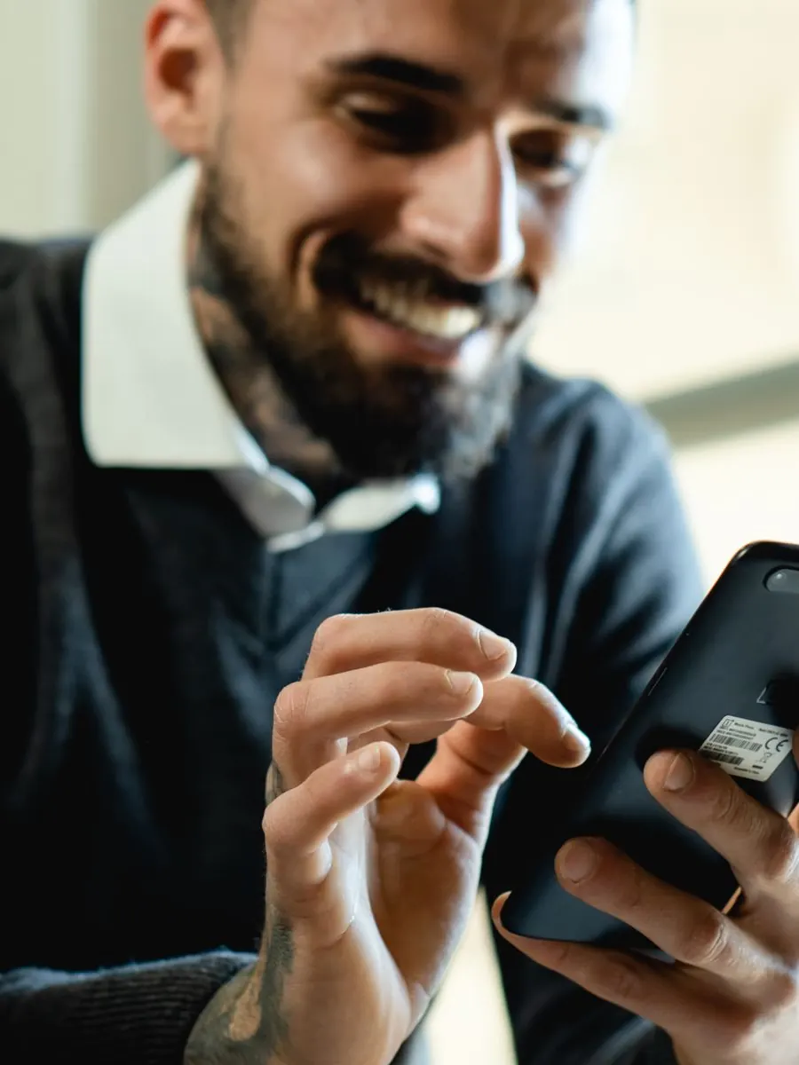 Smiling man texting on his phone